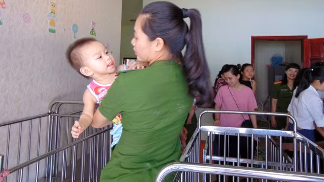 Các nữ học viên nô đùa cùng các trẻ mồ côi.