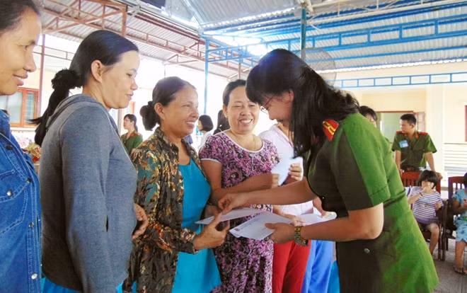 Thiếu tá Nguyễn Thị Thanh, Chủ tịch Hội Phụ nữ Trường T52, ân cần thăm hỏi, tặng quà cho nhân viên Làng hòa bình.