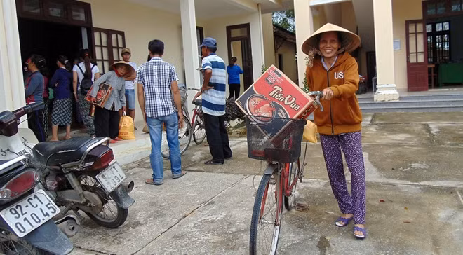 Người dân vui mừng chở quà tặng vừa nhận được trở về nhà.