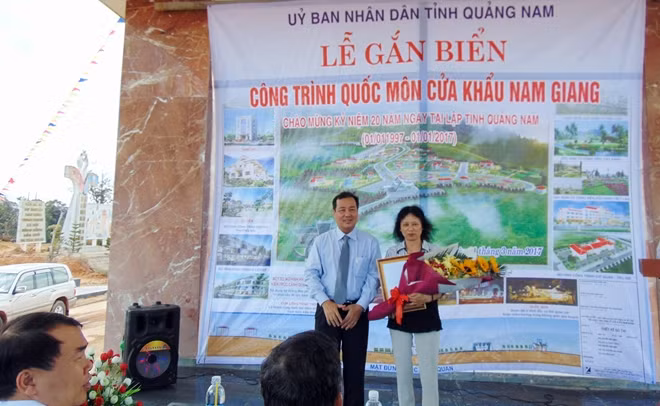 Ông Huỳnh Khánh Toàn trao Quyết định của UBND tỉnh Quảng Nam công nhận công trình Quốc môn CKNG là công trình chào mừng 20 năm tái lập tỉnh cho bà Thu Bồn.