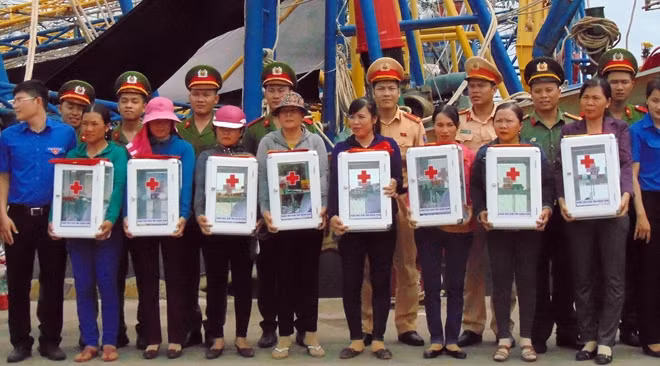Tặng cờ Tổ quốc và thùng thuốc cho các ngư dân xã biển Tam Quang.