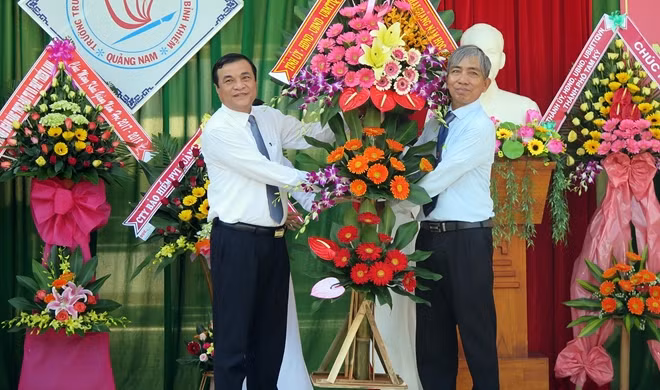Ông Phan Việt Cường, Ủy viên Trung ương Đảng, Phó Bí thư Thường trực Tỉnh ủy Quảng Nam (trái), tặng hoa chúc mừng thầy và trò Trường THPT chuyên Nguyễn Bỉnh Khiêm nhân dịp khai giảng năm học mới.