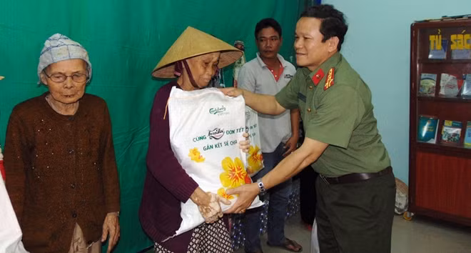 Đại tá Trà Thanh Hoàng, Trưởng phòng Công tác chính trị Công an tỉnh Quảng Nam, trao quà cho người dân.