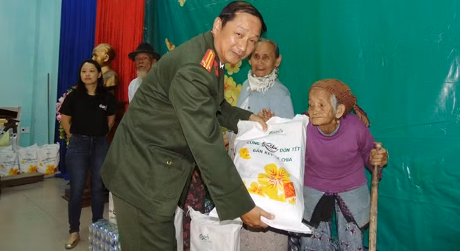 Trung tá Nguyễn Văn Long trao quà cho người dân quê nhà xã Điện Phương, thị xã Điện Bàn.