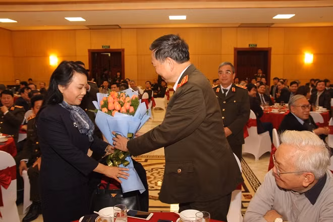 Bộ trưởng Tô Lâm tặng hoa chúc mừng Bộ trưởng Bộ Y tế Nguyễn Thị Kim Tiến. Ảnh Việt Hưng.