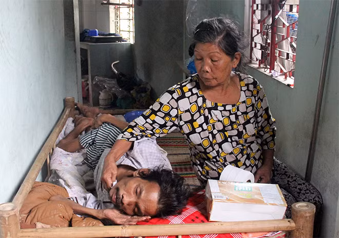 Bà Võ Thị Hạnh chăm sóc con trai mắc bệnh ung thư trên giường bệnh.