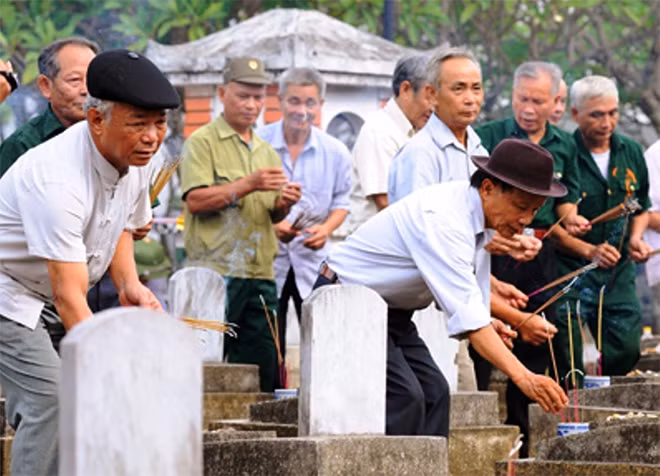 Các cựu chiến binh thắp hương tri ân đồng đội ở Nghĩa trang liệt sỹ Việt-Lào. Ảnh: Báo NA