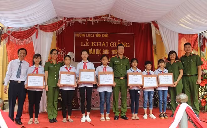 Trung tá Tô Anh Dũng (ở giữa) và các hoạt động tiếp sức cho học sinh đến trường.