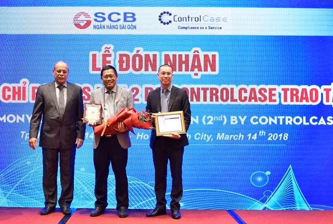Ô. Lê Minh Huấn (giữa) - P.TGĐ Phụ trách Khối CNTT SCB, đón nhận chứng chỉ PCI DSS lần 2 từ Ô. Suresh Dadlani (trái)- Giám đốc Điều hành ControlCase.