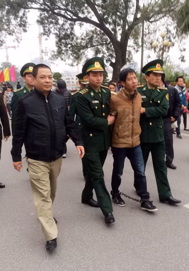 Trung tá Tùng (ngoài cùng bên trái) cùng lực lượng chức năng tiếp nhận đối tượng Trương Văn Hà từ Công an Trung Quốc.