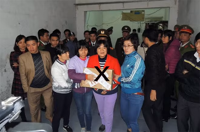 Cơ quan An ninh điều tra Công an tỉnh Hà Nam dẫn giải Trần Thị Nga (dấu X) và một số vật chứng liên quan.