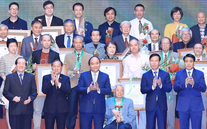 Thủ tướng Nguyễn Xuân Phúc trao tặng Bằng cống hiến cho gia đình kiến trúc sư tiêu biểu. Ảnh: TTXVN
