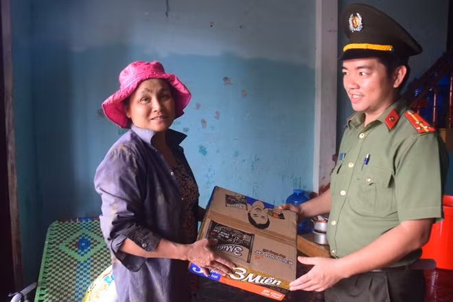 Trao quà cho người dân vùng còn ngập lụt.