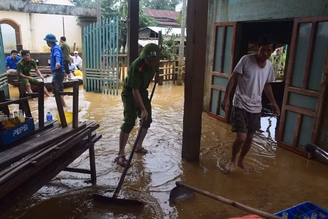 Các chiến sĩ đoàn thanh niên Công an tỉnh Quảng Nam giúp người dân dọn bùn sau lũ.
