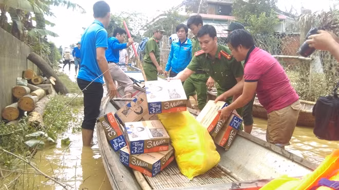 Dùng thuyền chở mì tôm, gạo qua sông.