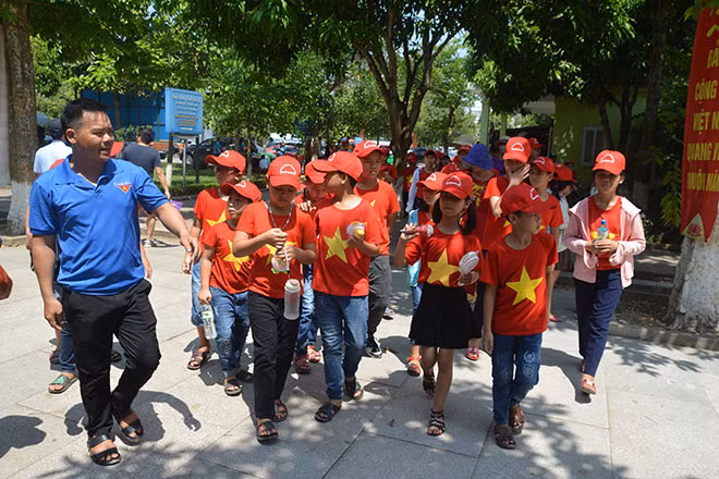 Các em học sinh trang phục cờ đỏ sao vàng hồ hởi đến khu di tích Kim Liên. Ảnh: Đức Vũ