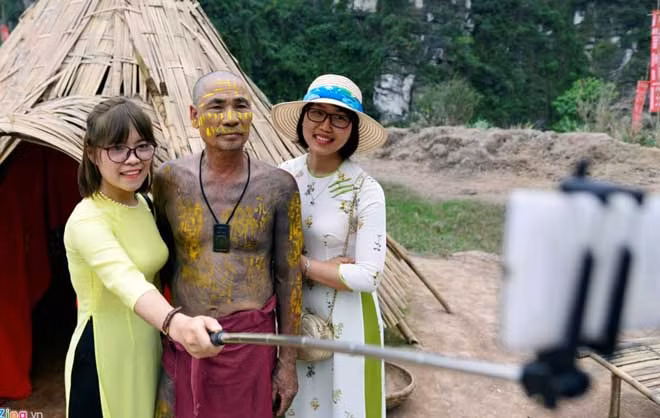 Hạnh, một du khách tham quan đến từ Hà Nội, hào hứng chụp ảnh cùng với thổ dân tại phim trường.
