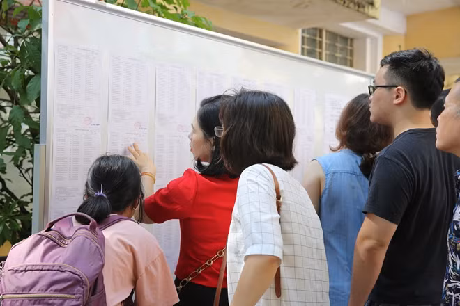 Thí sinh và phụ huynh tra cùng cứu thông tin tại điểm thi trường THPT Việt Đức sáng 6-6.