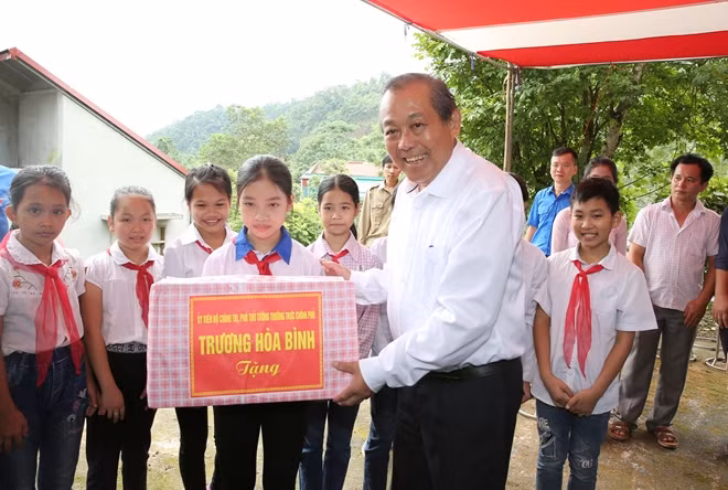 Phó Thủ tướng Trương Hòa Bình tặng quà các cháu nhi đồng thôn Tổng Mú, xã Dương Phong, huyện Bạch Thông.- Ảnh: VGP/Lê Sơn