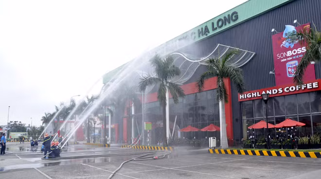 Hai lực lượng dùng lăng phun nước dập tắt đám cháy.