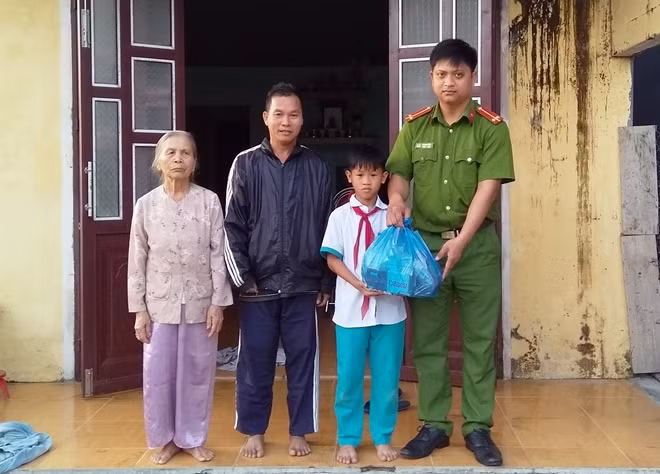 Trung úy Lê Oanh Việt tặng quà, trao tiền hỗ trợ “Cùng em đến trường” cho em Đạt.