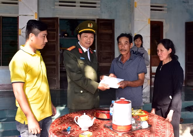 Đại diện Báo CAND trao tiền hỗ trợ cho bố, mẹ chiến sĩ Công an Lê Chí Phước.