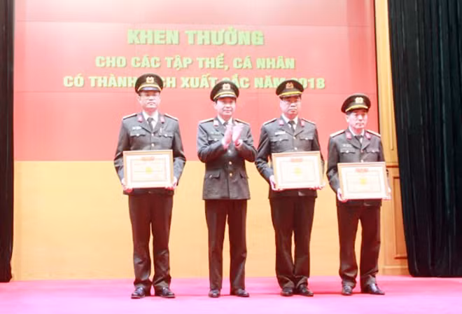 Thiếu tướng Nguyễn Minh Chính, Cục trưởng Cục An ninh mạng và Phòng chống tội phạm CNC, trao danh hiệu đơn vị quyết thắng cho các tập thể.