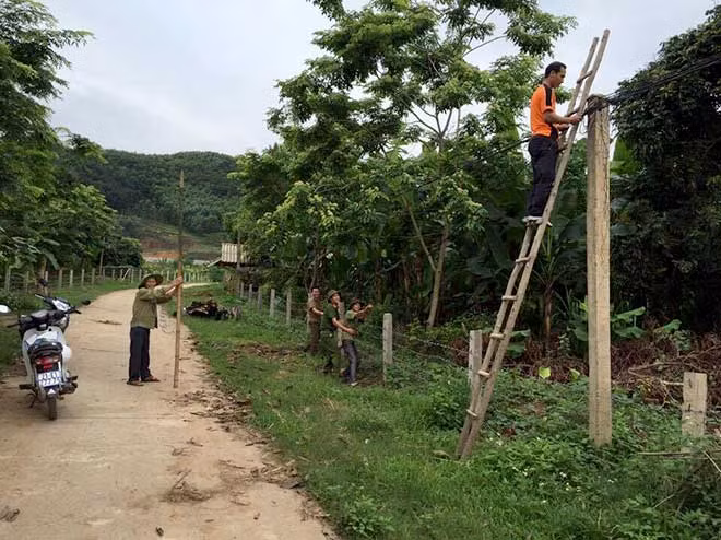Tổ công tác tăng cường của Công an huyện Văn Yên mắc đường dây điện cho người dân.