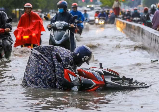 "Tôi đang dắt bộ thì bị sóng do ôtô chạy ngang tạo ra đánh ngã nhào, người ướt sũng. Đã lâu mới thấy đường này bị ngập nặng như vậy", chị Hân nói.