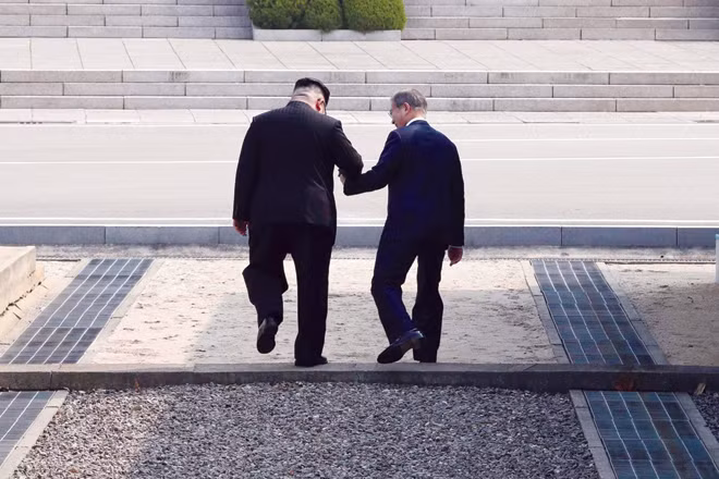 Kim Jong-un, lãnh đạo CHDCND Triều Tiên (trái), và Moon Jae-in, Tổng thống Hàn Quốc, nắm tay nhau ngày 27-4 khi họ đi qua phía Bắc biên giới Khu phi quân sự giữa hai quốc gia. Kim Jong-un là nhà lãnh đạo đầu tiên của Triều Tiên đặt chân đến Hàn Quốc kể từ khi đình chiến Chiến tranh Triều Tiên năm 1953. (Ảnh: Inter-Korean Summit Press Corps)