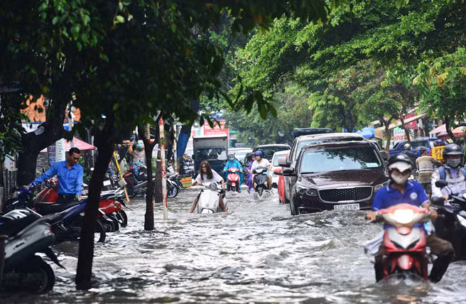 Người dân hai bên đường Quốc Hương cho biết tuyến đường bị trũng thấp nhiều đoạn. Sau những cơn mưa lớn kéo dài khoảng 30 phút, nơi đây thường ngập sâu khiến nhiều ôtô, xe máy bị chết máy. Ảnh: Lê Quân