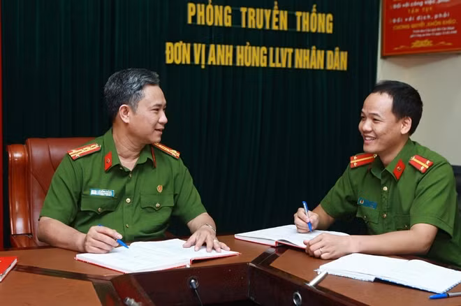 Đại tá Lê Hồng Thắng (bìa trái) trao đổi nghiệp vụ với đồng đội.