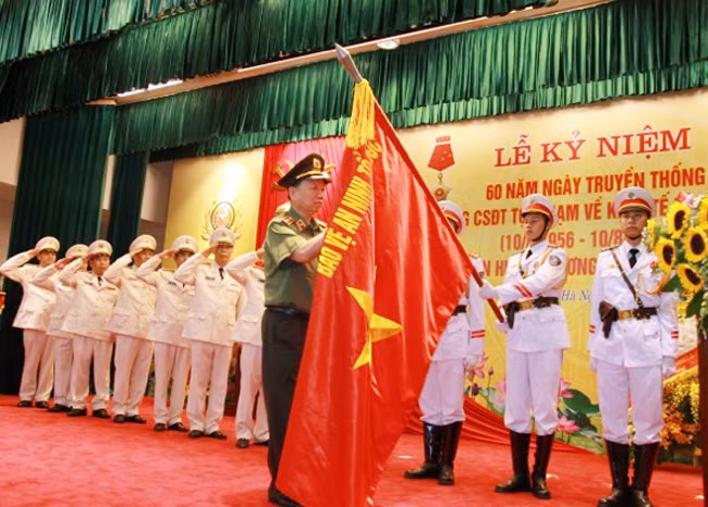 Bộ trưởng Tô Lâm gắn Huân chương Quân công hạng Nhất lên Cờ truyền thống của lực lượng CSĐT tội phạm về KT và chức vụ.