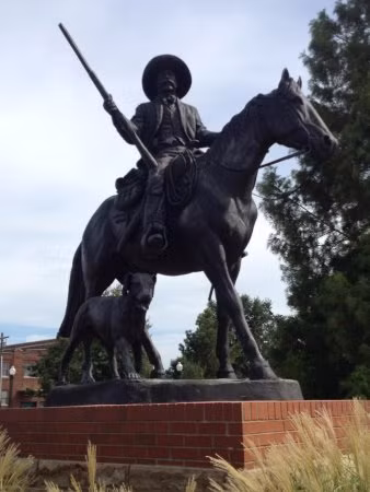 Bức tượng của Bass Reeves bằng đồng ngồi trên lưng ngựa, cùng với chú chó của ông. Bức tượng của Bass Reeves bằng đồng ngồi trên lưng ngựa, cùng với chú chó của ông.
