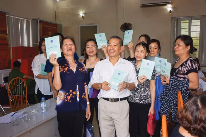 Người dân tham gia bảo hiểm xã hội tự nguyện hân hoan nhận sổ. Người dân tham gia bảo hiểm xã hội tự nguyện hân hoan nhận sổ.