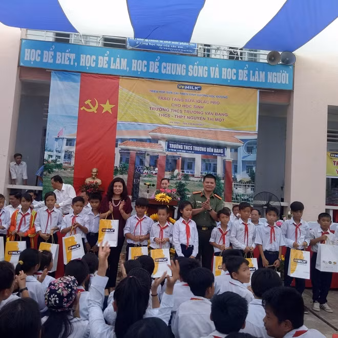 Thiếu tá Nguyễn Văn Bình – Phó trưởng CQĐD Báo CAND và bà Nguyễn Thị Thu Phương, tổng giám đốc VP Milk tặng sữa cho các em học sinh.