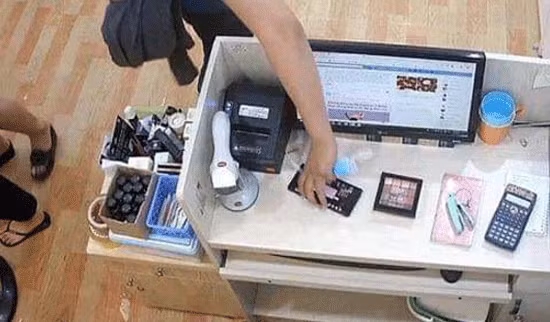 Hình ảnh trích xuất từ camera một đối tượng nữ (áo xanh) đang trộm điện thoại của nhân viên bán hàng. Hình ảnh trích xuất từ camera một đối tượng nữ (áo xanh) đang trộm điện thoại của nhân viên bán hàng.