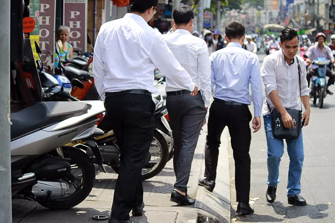 Lề đường bị lấn chiếm nên người đi bộ phải đi xuống lòng đường.