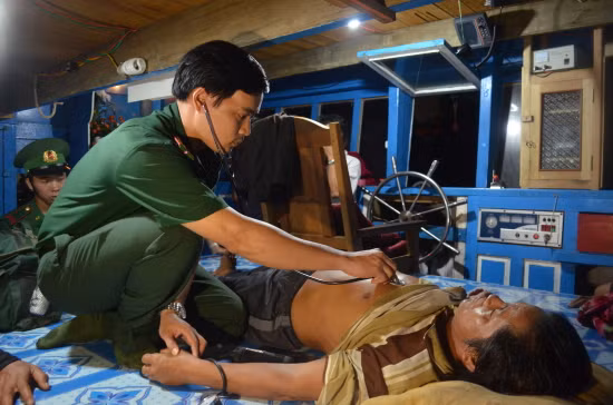 Bác sĩ Bộ đội biên phòng Bình Định kiểm tra sức khỏe ngư dân lâm nạn sau khi đưa về đến cảng Mũi Tấn. Ảnh: Thanh Bình.