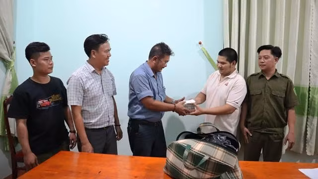 Anh Hiếu (thứ 2 từ phải sang) cùng Công an xã Đồng Tiến trao trả số tiền 280 triệu đồng cho ông Nguyễn Văn Tài.