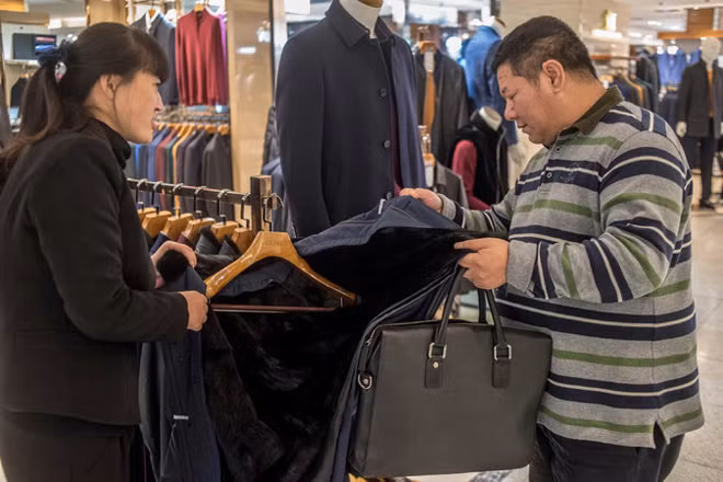 Thợ săn hàng giả Ji xem xét một kiểu quần áo nghi hàng giả.