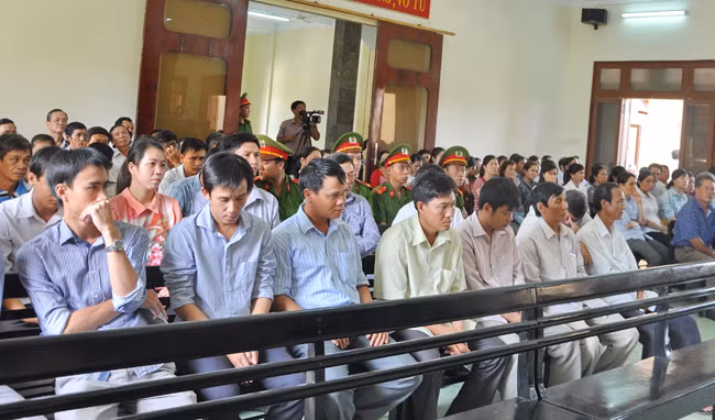 Các bị cáo ngồi ở hai hàng ghế đầu nghe tòa kiểm tra căn cước.