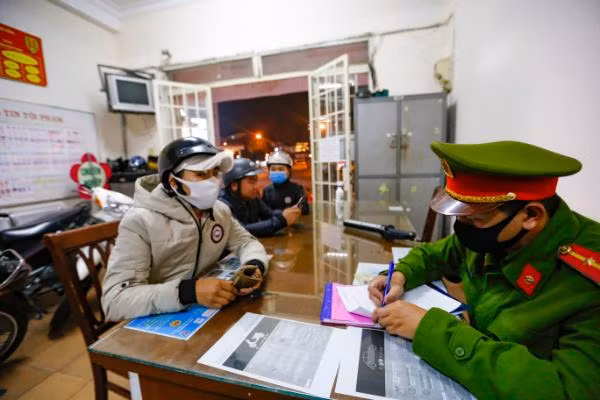 Công an lập biên bản người không đeo khẩu trang khi tới nơi công cộng