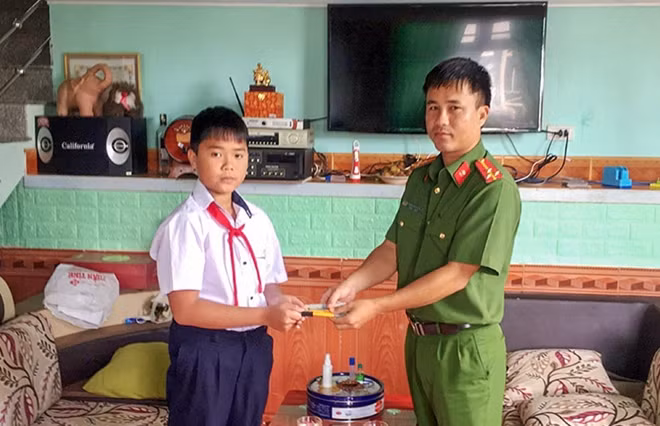 Em Cao Chí Nguyên bàn giao số tiền nhặt được cho Công an phường 1, TP Bảo Lộc tìm chủ nhân để trả lại