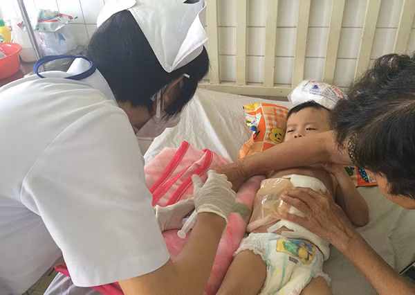 Bà ngoại luôn luôn túc trực bên cháu Hải.