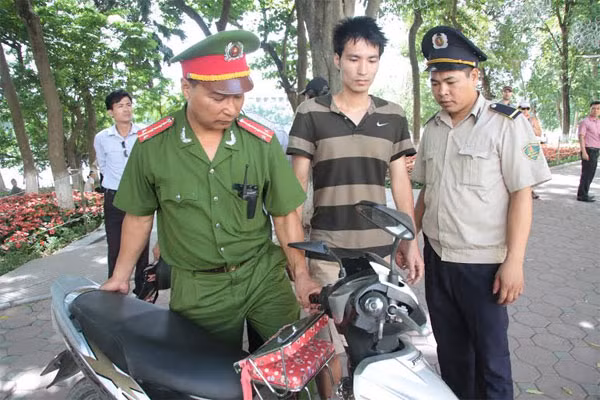 Sau khi lên bờ, nam thanh niên (ở giữa) được đưa về Công an phường Hàng Trống xử lý - Ảnh: Thanh Xuân