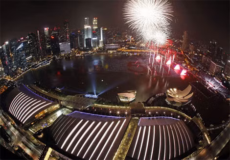 Pháo hoa thắp sáng bầu trời trên vịnh Marina, Singapore. Người dân viết lời ước của mình lên 25.000 hình cầu xếp dọc, vừa đón chào năm mới, vừa kỷ niệm 50 ngày Độc Lập. Ảnh: Reuters.