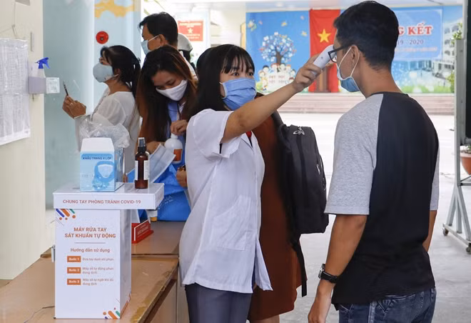Kiểm tra thân nhiệt, rửa tay bằng dung dịch và đeo khẩu trang đúng quy định là những việc cần làm trước khi vào phòng thi kỳ thi năm nay.