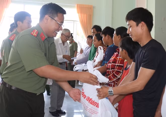 Đại uý Nguyễn Hồ Đăng Khoa, Bí thư Đoàn thanh niên Công an tỉnh Đồng Tháp trao quà cho người dân.