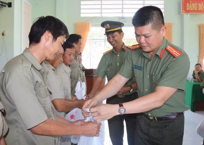 Đại diện Báo CAND và Công an huyện Tân Hồng trao quà cho người dân.